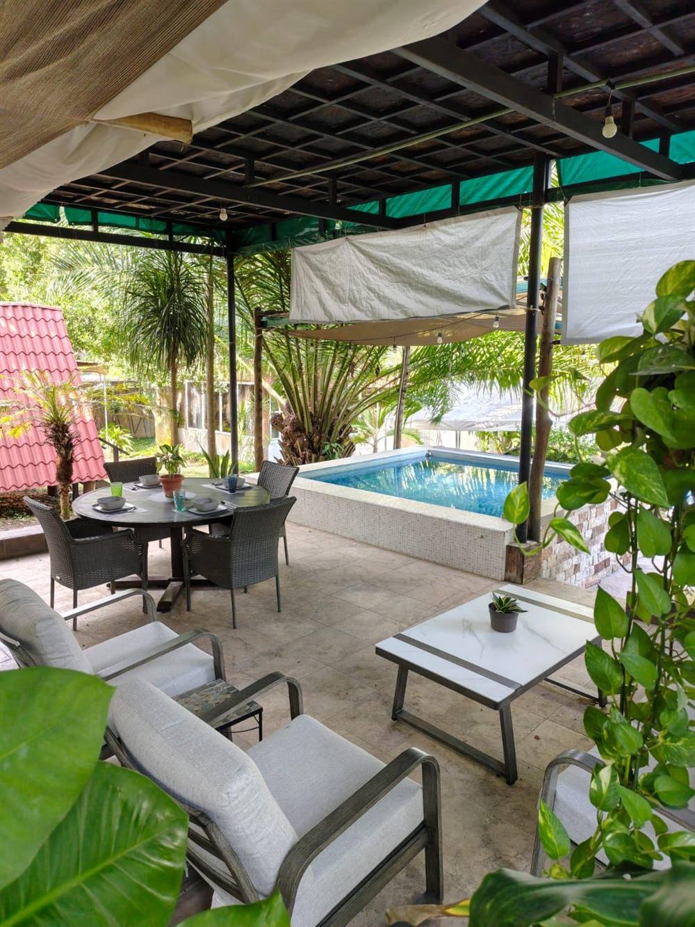 Alberca privada con comedor techado y zona de descanso
